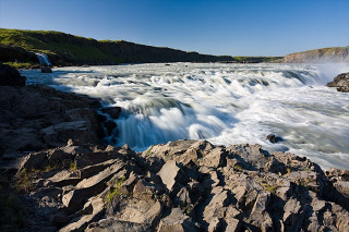 UrriÃ°afoss waterfall in river Ã?jÃ³rsÃ¡ in South Iceland. ViÃ° UrriÃ°afoss Ã­ Ã?jÃ³rsÃ¡. UrriÃ°afoss Ã­ Ã?jÃ³rsÃ¡ er vatnsmesti foss landsins og einn sÃ¡ tignarlegasti. Fossinn er nokkrum km ofan Ã?jÃ³rsÃ¡rvers og stutt sunnan Ã?jÃ³rsÃ¡rbrÃºar. FurÃ°u hljÃ³tt hefur veriÃ° um Ã¾essa nÃ¡ttÃºruperlu hingaÃ° til. Ã?rÃ¡tt fyrir aÃ° hann sÃ© aÃ°eins steinsnar frÃ¡ fjÃ¶lfarinni Ã¾jÃ³Ã°leiÃ° er Ã¾aÃ° fyrst nÃº sem hann er gerÃ°ur vel aÃ°gengilegur fyrir ferÃ°afÃ³lk. MeÃ°alrennsli Ã­ UrriÃ°afossi er um 360 mÂ³/sek. Lax gengur upp Ã?jÃ³rsÃ¡ aÃ° fossinum og nokkuÃ° upp fyrir hann.