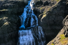 Fossinn Drynjandi í Hvalá. Rennsli árinnar verður aðeins 5% af eðlilegu rennsli og þessi 77 m foss hverfur nánast.Fólkið efst á myndinni gefur hugmynd um stærð fossins.